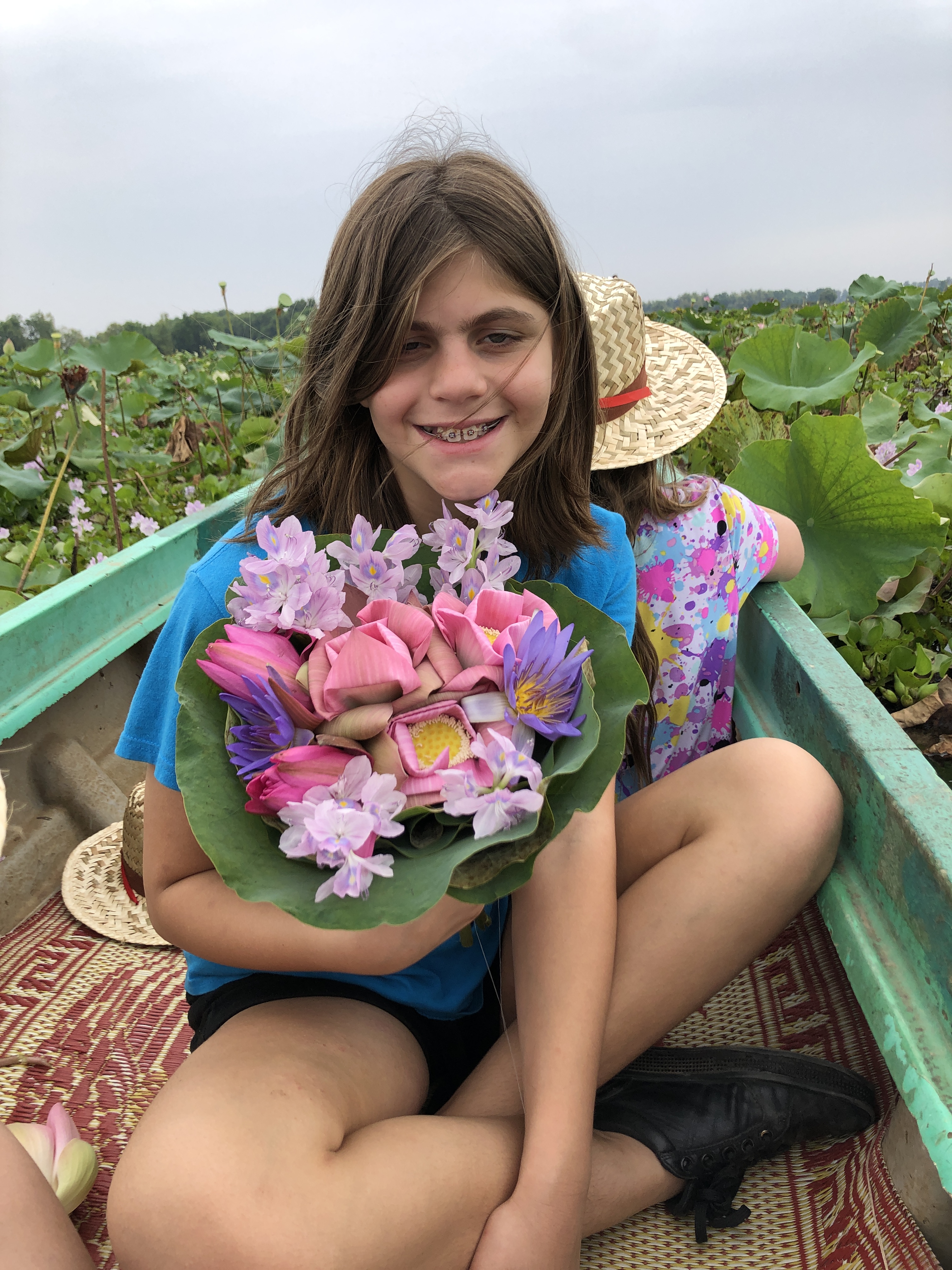 R with a bouquet of aquatic flowers: water lily, water hyacinth, and lotus.
