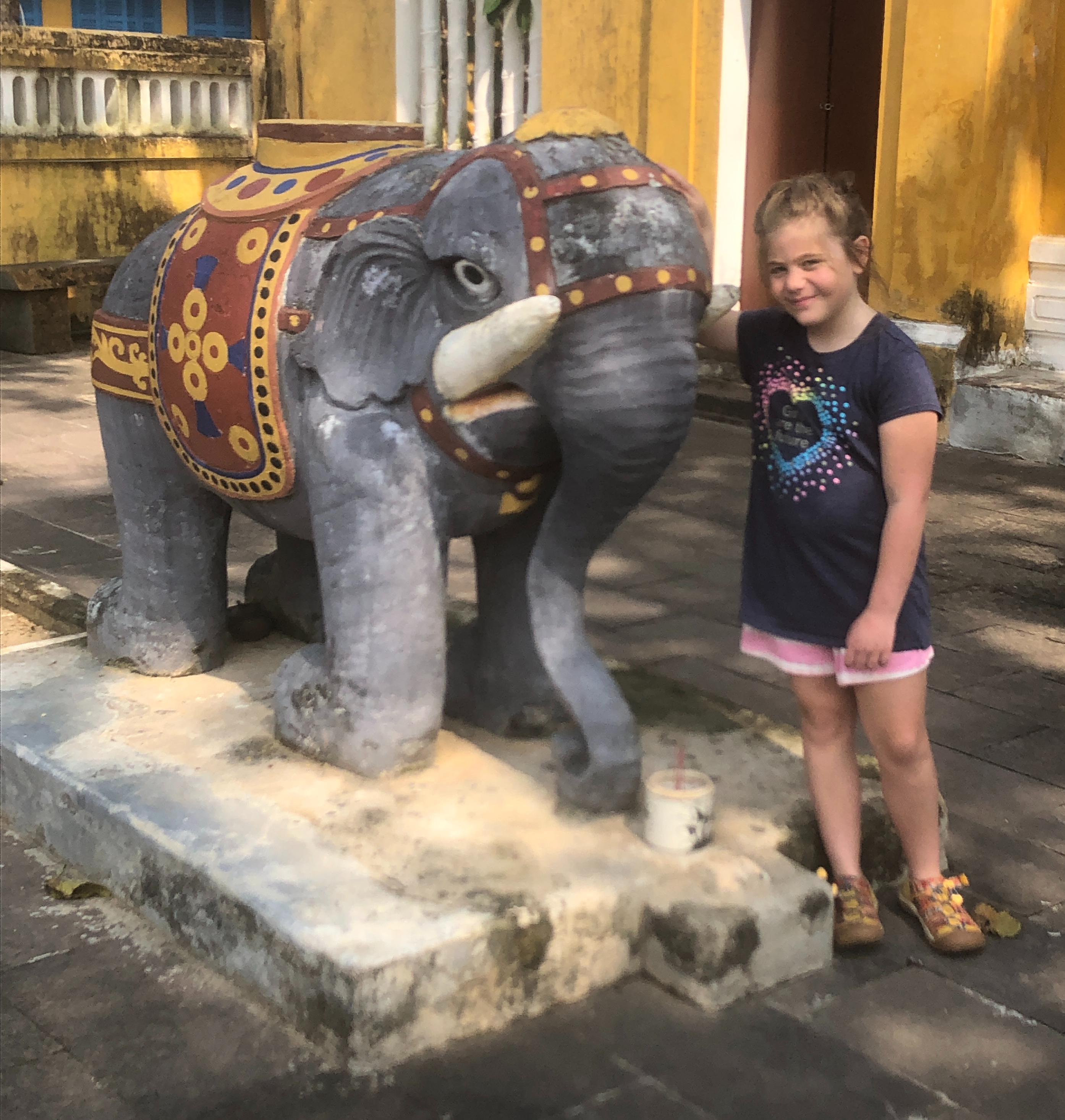 E standing next to an elephant statue.