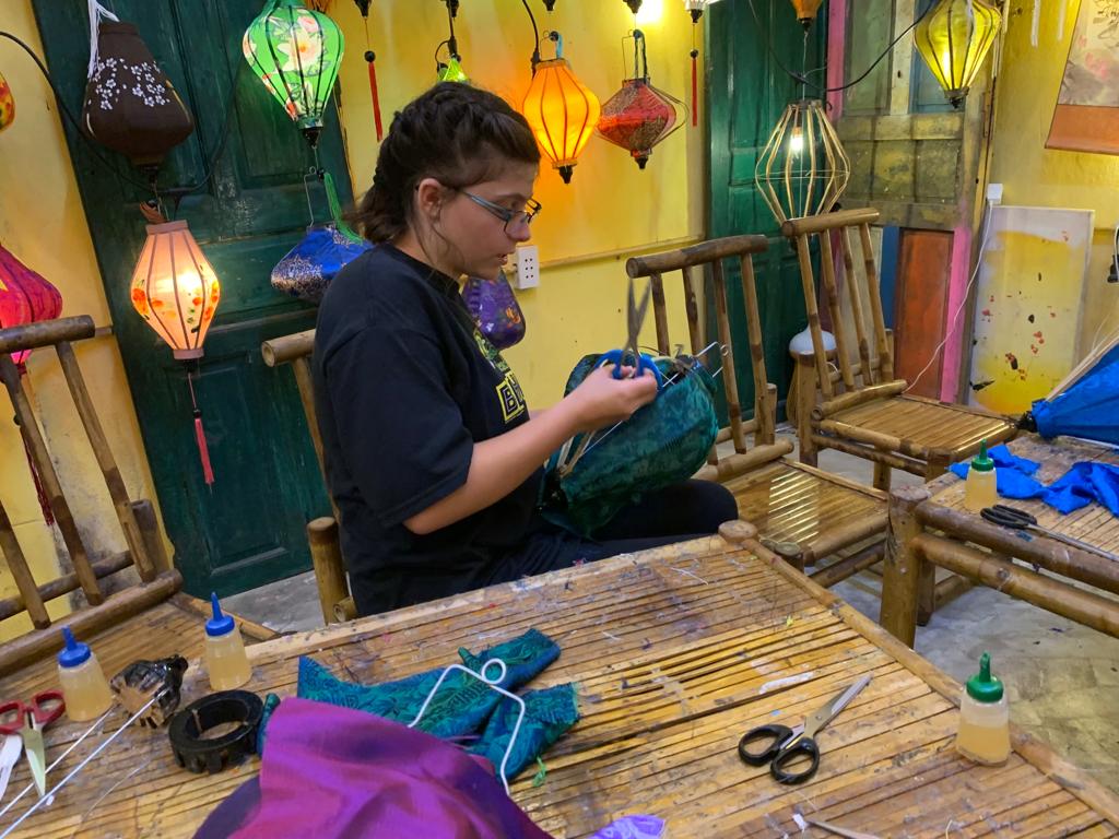 K in the lantern workshop, applying silk to the bamboo frame.